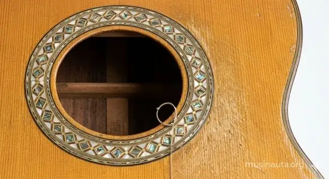 Detalle de la caja de resonancia de una guitarra flamenca española con incrustaciones de nácar y clavijero de madera